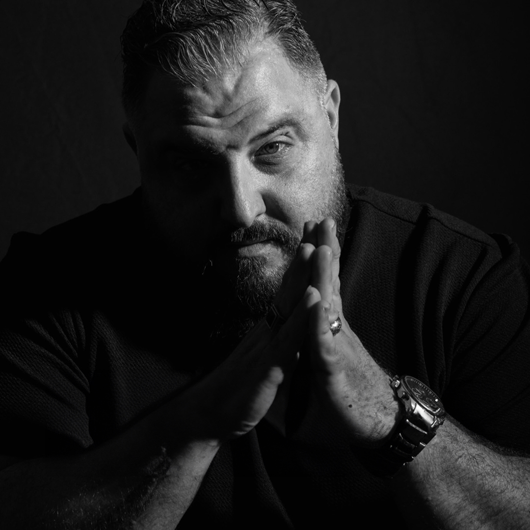 Comedian Lu Sicilianu Raggiatu portrait in a dark black and white image with light shining only on his left side