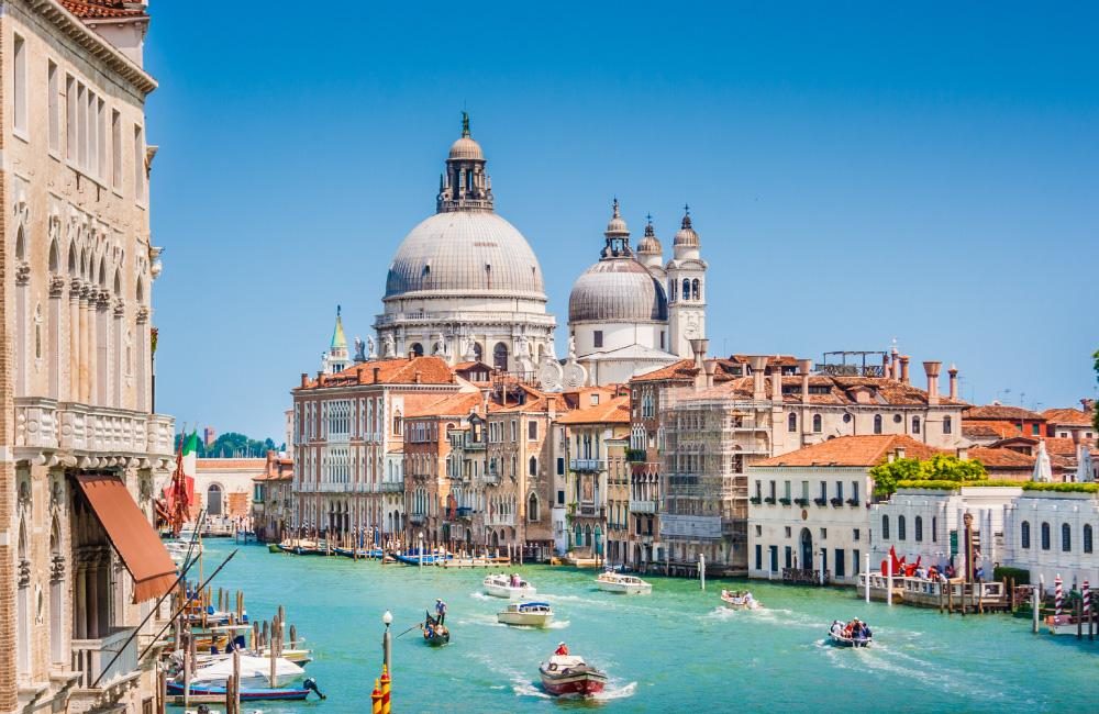 The city of Venice, showing boats on the canal and Basilica di Santa Maria della Salute.