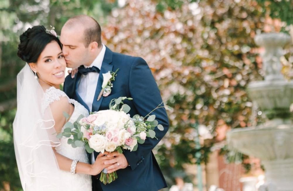 A bride and groom pose for a photo on their wedding day at the Columbus Centre courtyard.