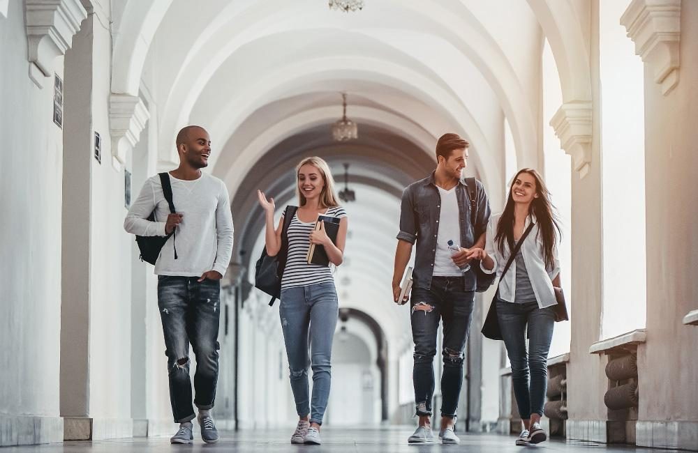 A group of students walking along an outside corridor.