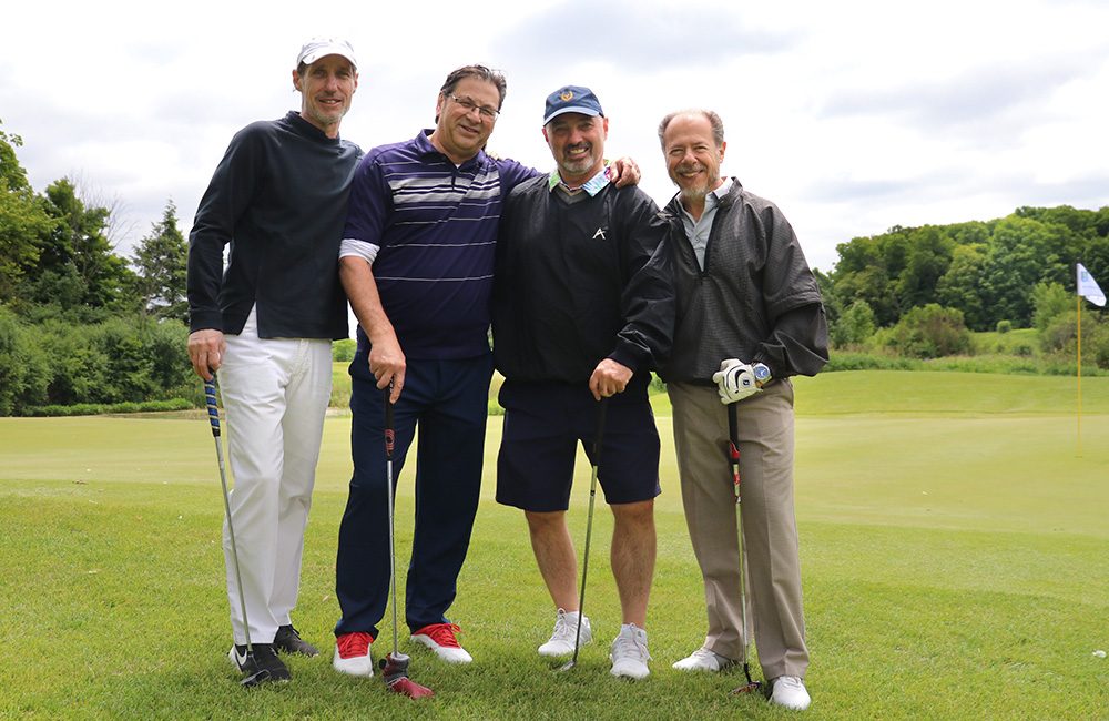 4 men standing in a golf course