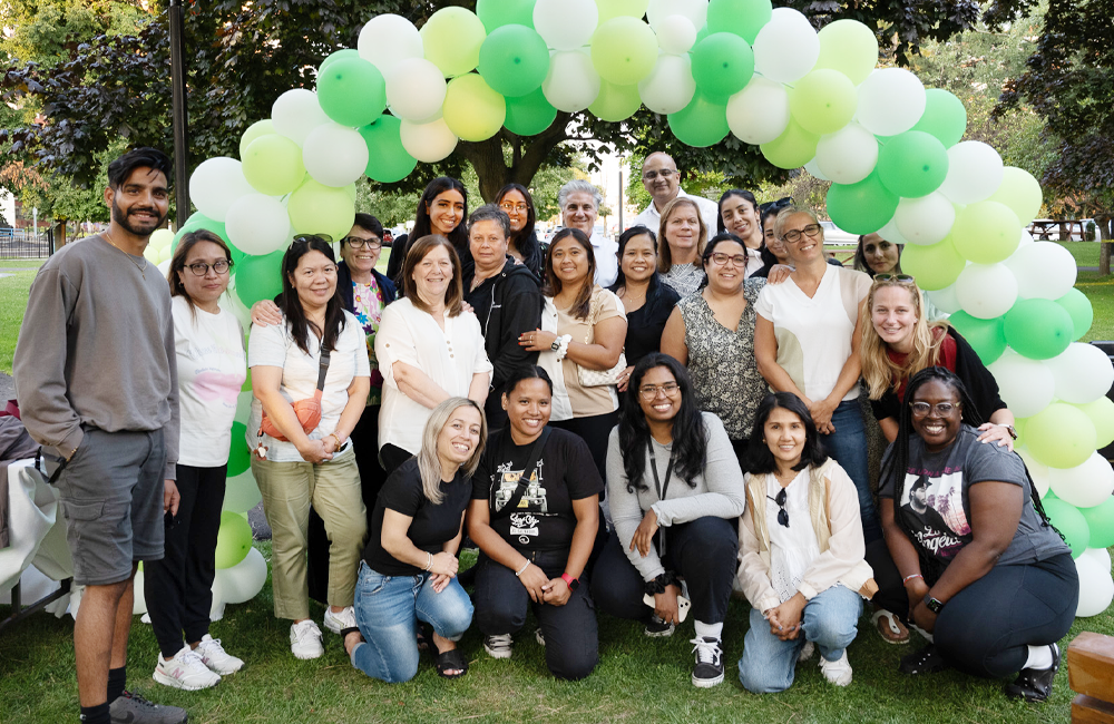 Villa Charities staff seen under an arch of balloons at a staff event